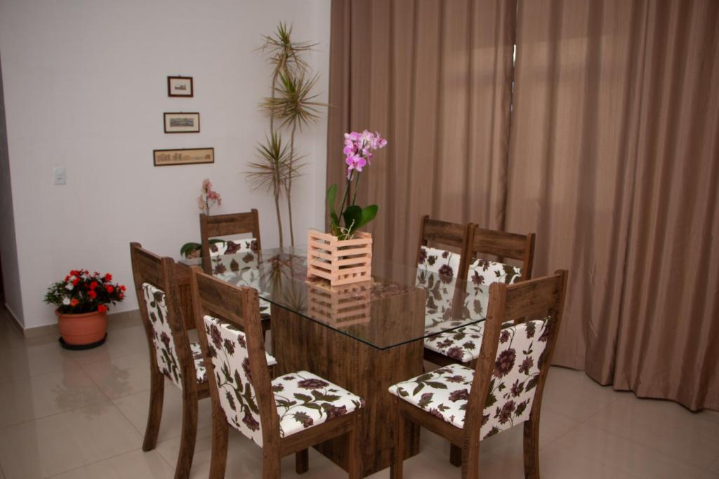 a dining room with a table and chairs with flowers on it at Caparaó Casa Feliz in Alto Caparao
