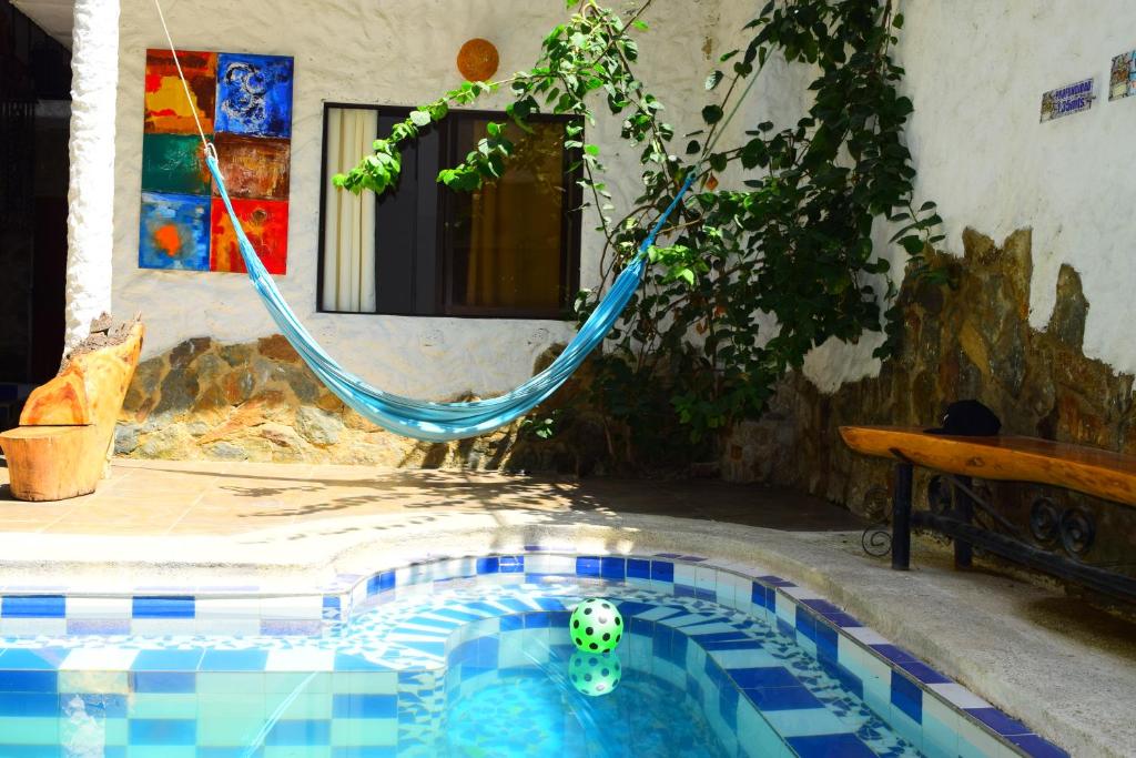 una piscina con una hamaca en un patio en RokaDura Hostel, en Santa Marta