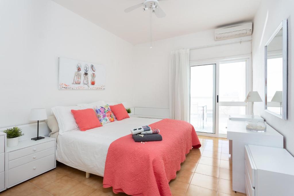 a white bedroom with a bed with a red blanket at Frontline Beach Apartment in San Andrés
