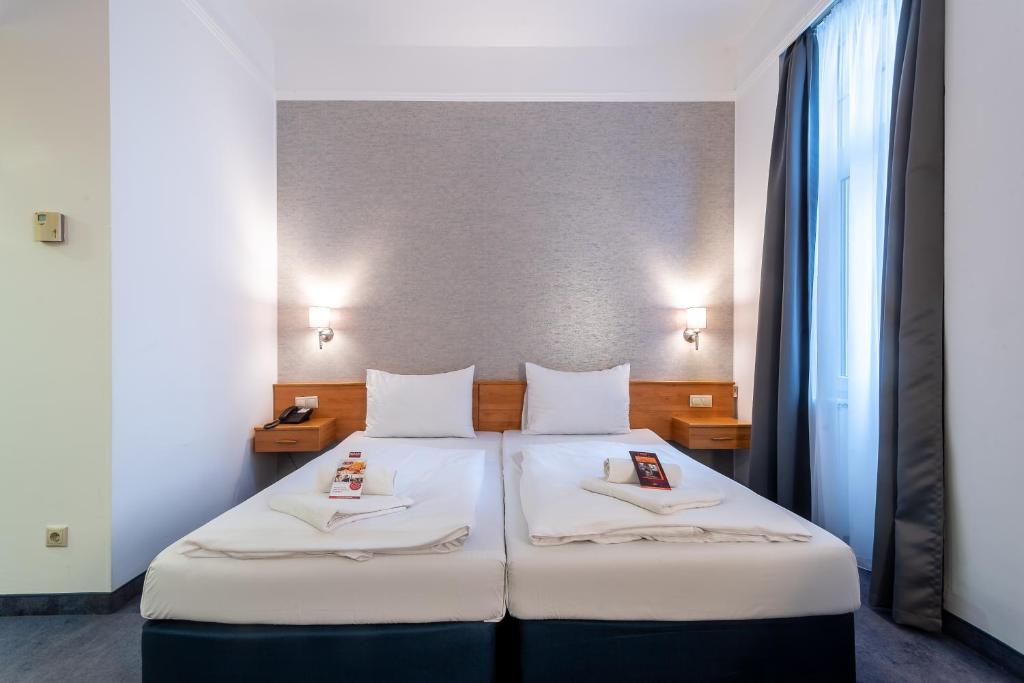 Postel nebo postele na pokoji v ubytování East City Budapest