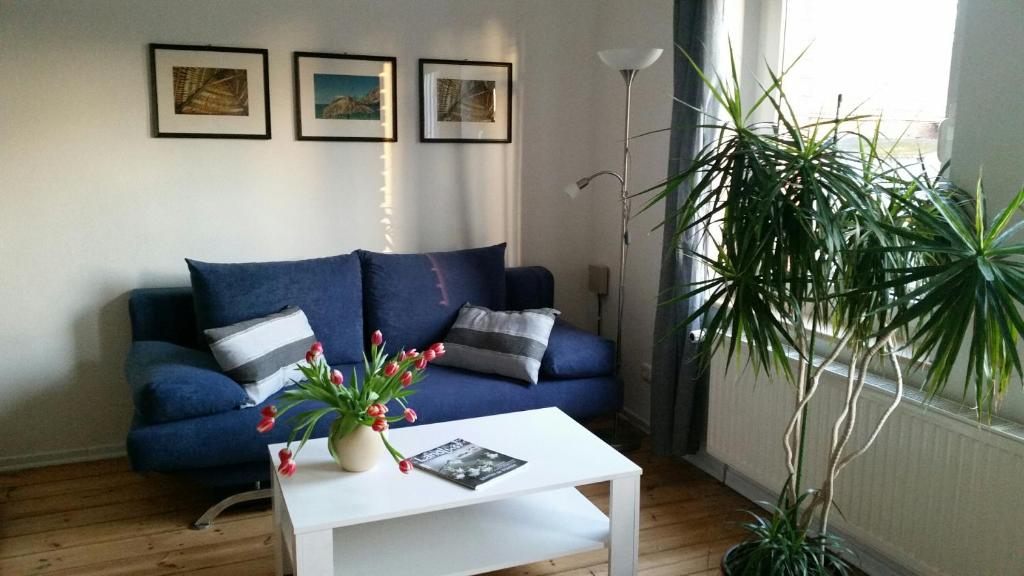 sala de estar con sofá azul y mesa en Hof Heideland 1, en Eichholz