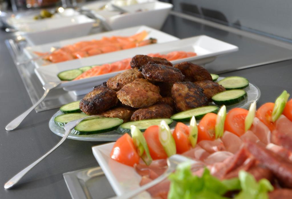a buffet of food with meatballs and vegetables on plates at Hotel Spiegel in Cologne