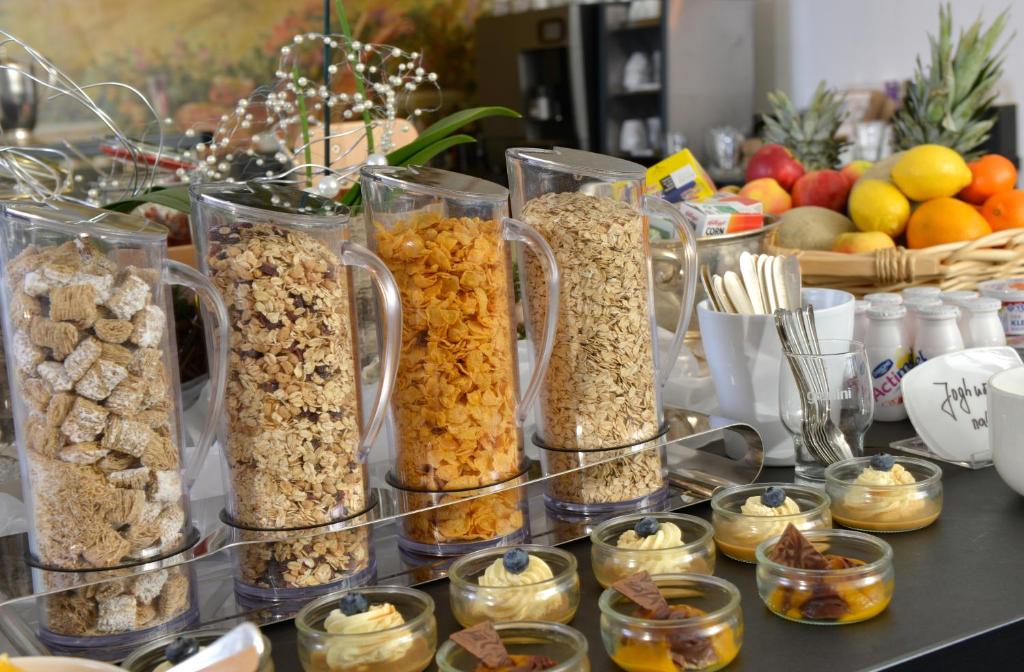 a table topped with glass containers filled with different types of food at Hotel Spiegel in Cologne