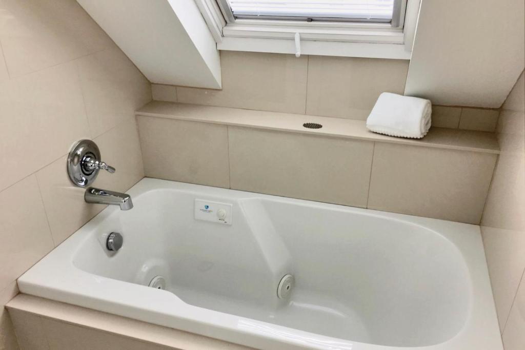 a white bath tub in a bathroom with a window at Benchmark Inn in Provincetown