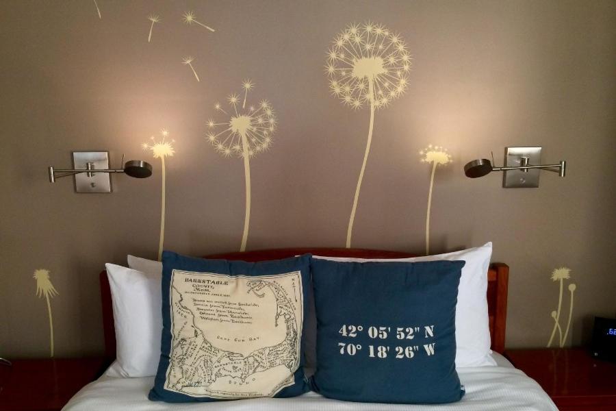 a bedroom with a bed with dandelions on the wall at Benchmark Inn in Provincetown