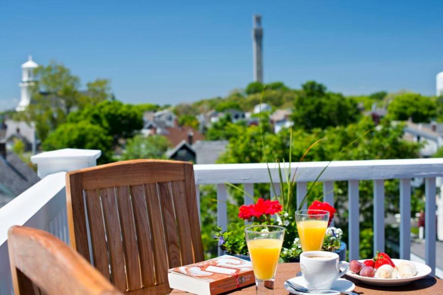 a table with a plate of food and two glasses of orange juice at Benchmark Inn in Provincetown