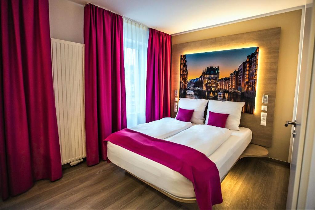 a bedroom with a large bed with red curtains at Hotel Luckys Inn in Hamburg