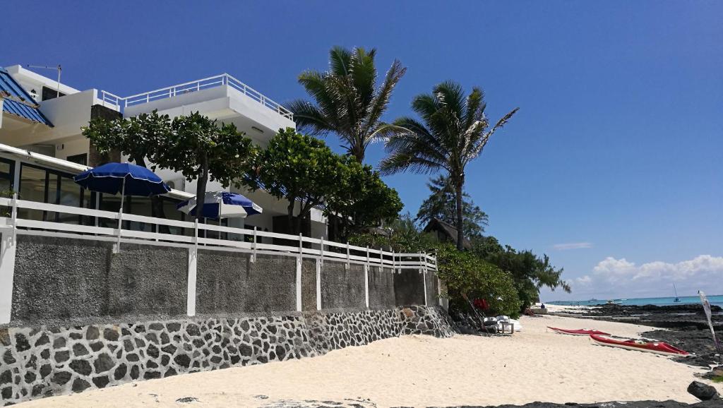 藍海灣的住宿－青藍旅館，海滩上的一座建筑,上面有树木和遮阳伞