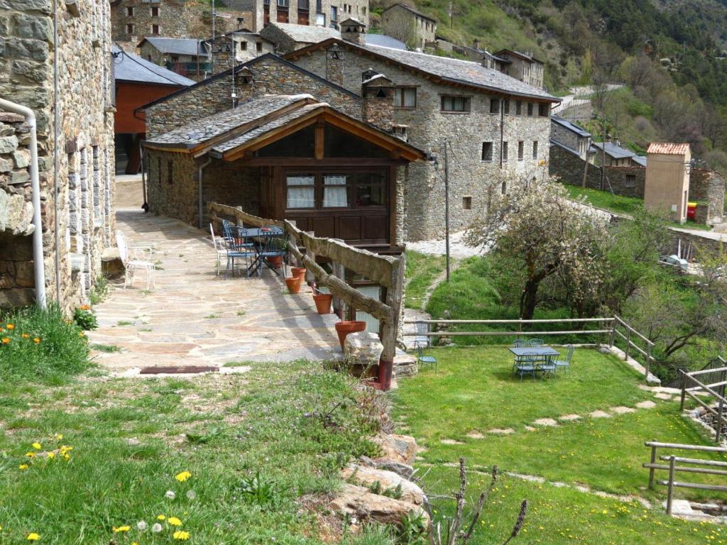 un bâtiment avec une terrasse couverte en bois dans un village dans l'établissement Cal Mestre, à Fornells de la Muntanya