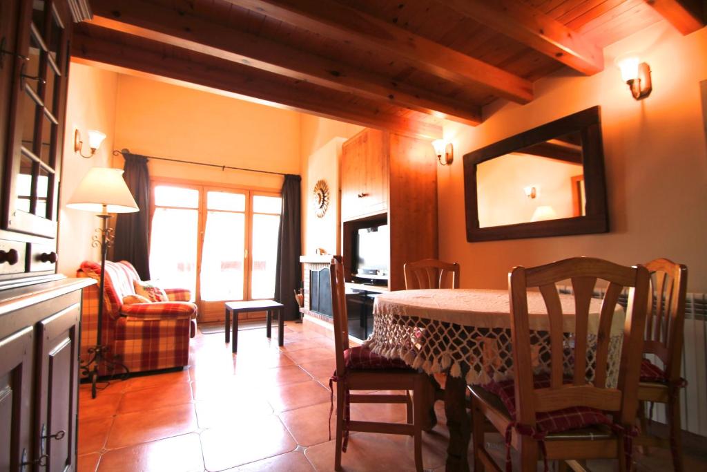 a dining room with a table and a living room at Borda Pascol, Atico Duplex en Tarter Zona Grandvalira in Canillo