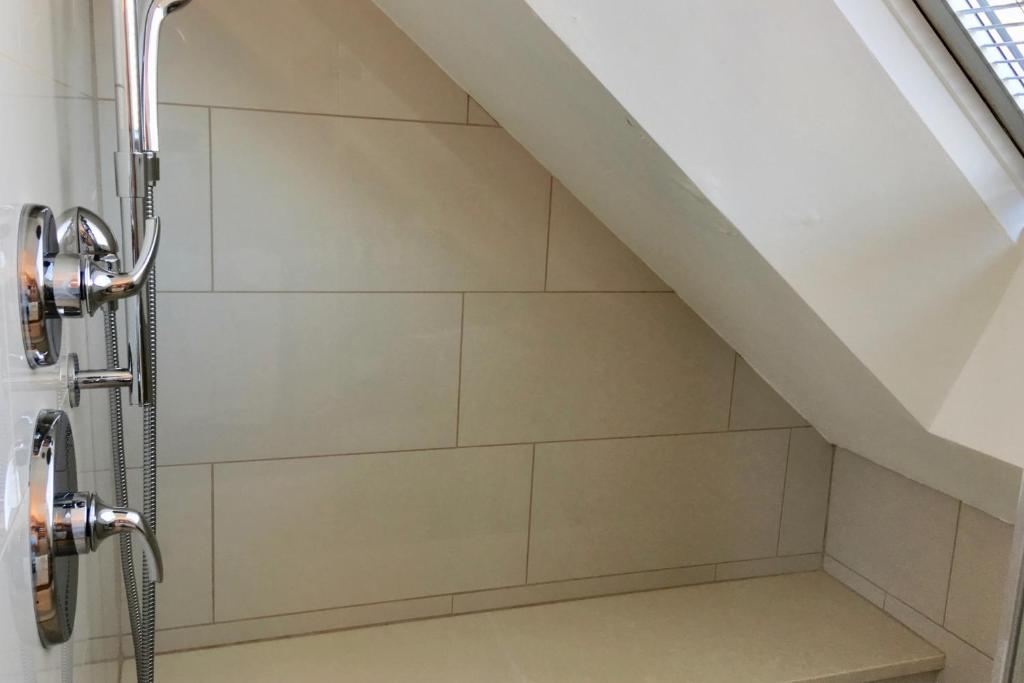a shower in a bathroom with a staircase at Benchmark Inn in Provincetown