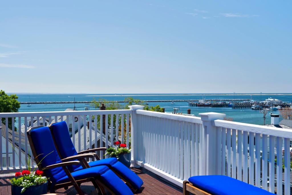 two blue chairs on a balcony with a view of the water at Benchmark Inn in Provincetown
