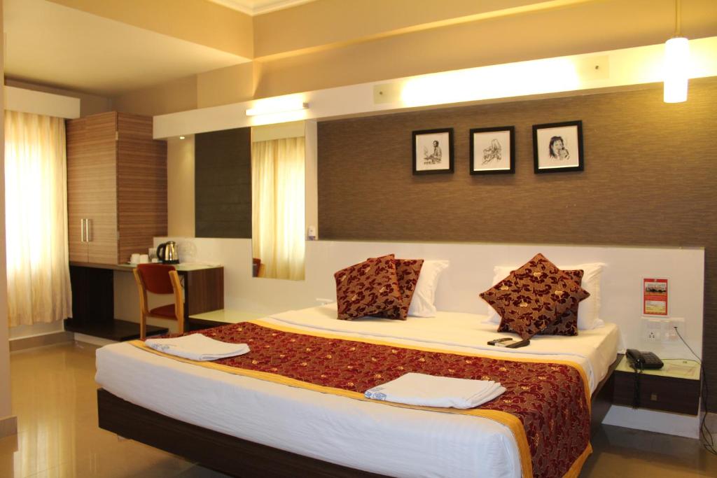 a bedroom with a large bed in a room at Hotel Pooja International in Dāvangere
