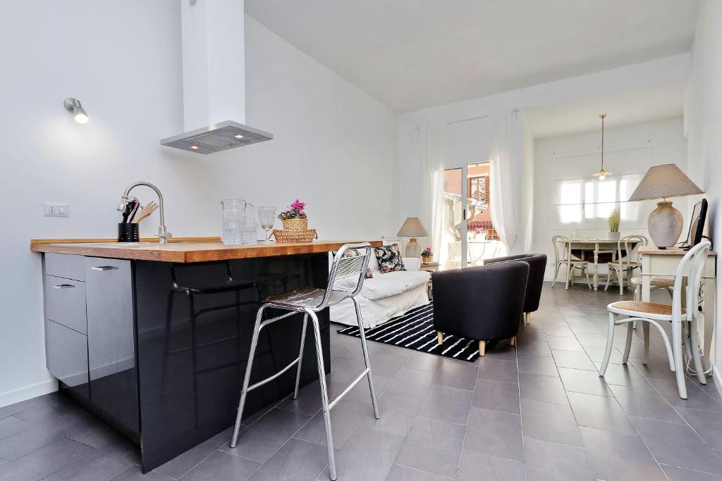 a kitchen and living room with a counter and chairs at Monti charming apartment - Rome short let Service in Rome