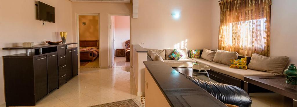 Résidence Bab El Janoub في ورززات: غرفة معيشة مع أريكة وطاولة