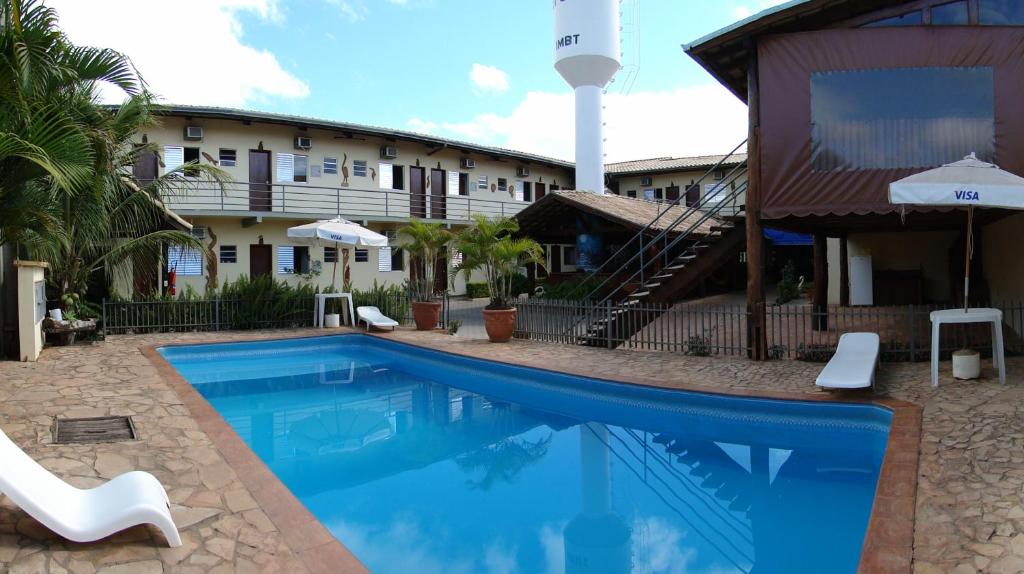 a swimming pool in front of a hotel at Hotel Refugio in Bonito