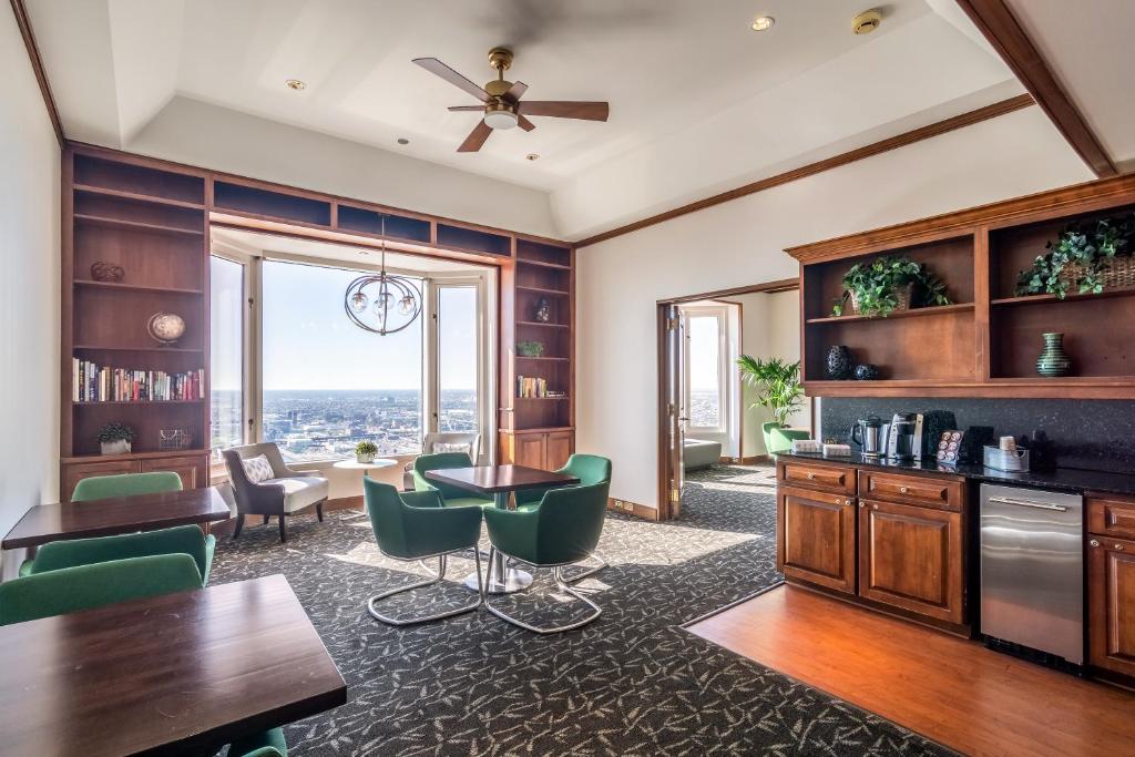 a living room with a table and green chairs at The Buckingham Hotel in Chicago