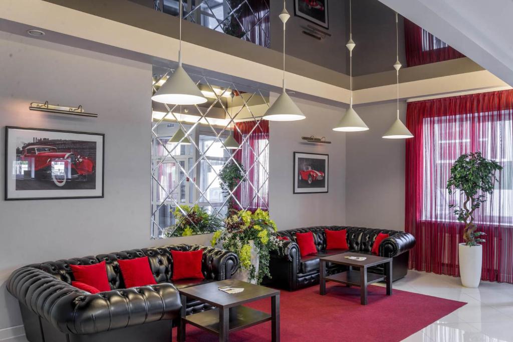 イジェフスクにあるHotel Narcissのリビングルーム(黒い革張りのソファ、赤い枕付)