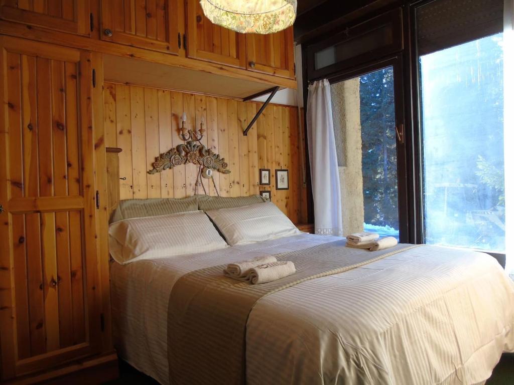 - une chambre avec un lit et 2 serviettes dans l'établissement Hs4U Chalet sulle piste - Dolomiti - Madonna di Campiglio, à Madonna di Campiglio