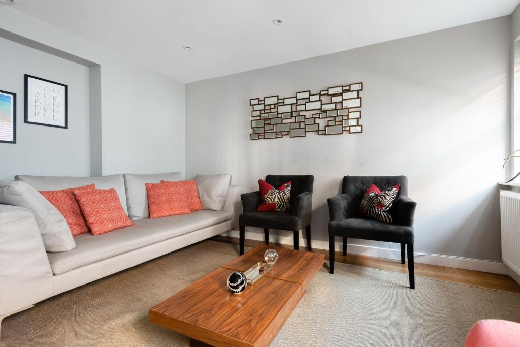 a living room with a couch and two chairs at The Norfolk Maisonette - Lovely 4BDR Mews in London