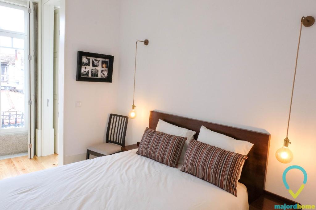a bedroom with a white bed with two pillows at Simply Porto in Porto