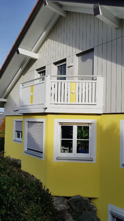 a yellow and white house with a balcony at Haus Marlene in Memmingen