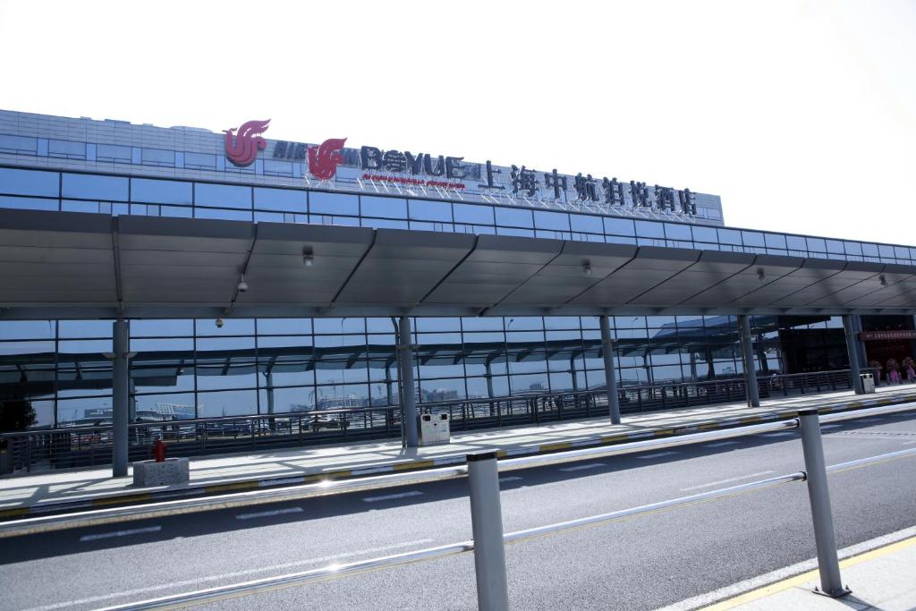a building with a sign on the side of a road at Shanghai Hongqiao Airport Hotel - Air China in Shanghai