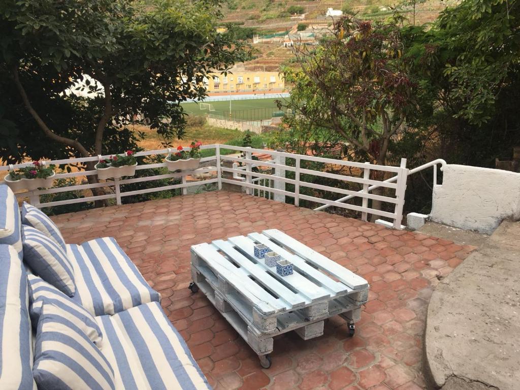 a patio with two benches and a white fence at MULAGUA in Agulo
