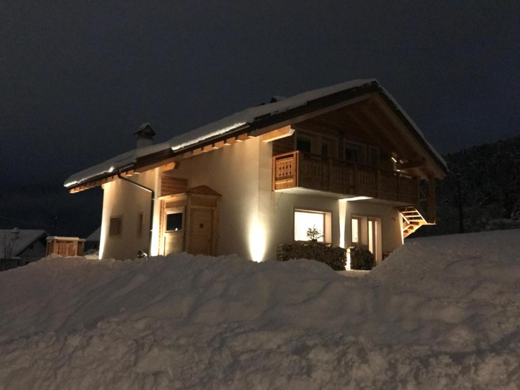 a small house in the snow at night at Chalet delle Dolomiti in Pieve di Cadore