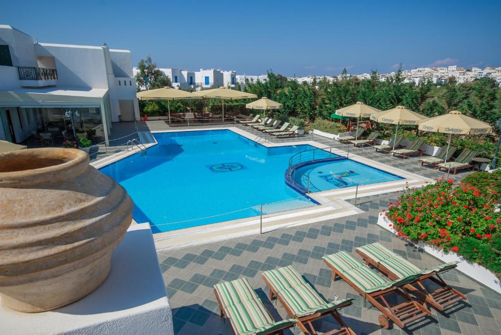 a swimming pool with lounge chairs and umbrellas at a resort at Astir Of Naxos in Naxos Chora