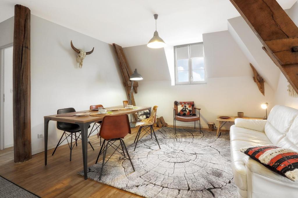 een woonkamer met een tafel en een bank bij Les toits de Lascaux in Montignac