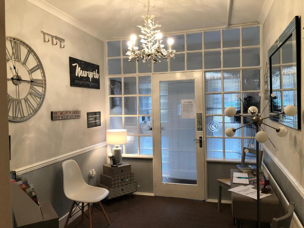 a room with a chandelier and a chair and a window at The Georgian Guesthouse in Alnwick