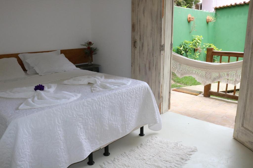 een slaapkamer met een bed met een wit dekbed bij Pousada Amor de Casa in Trancoso
