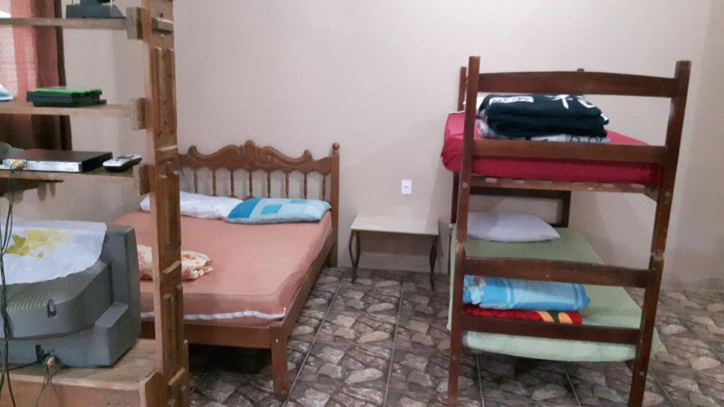 een kamer met 2 stapelbedden, een bed en een bureau bij Suíte ampla com cozinha Ibitipoca in Conceição da Ibitipoca