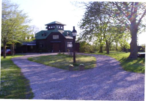 una grande casa nera con una torre dell'orologio in cima di Chokladvillan a Visby