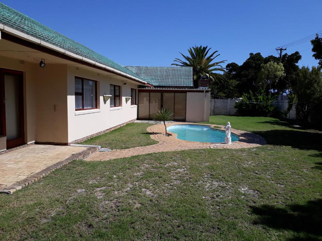 a house with a swimming pool in the yard at DJ'S B&B in Table View Cape Town in Cape Town