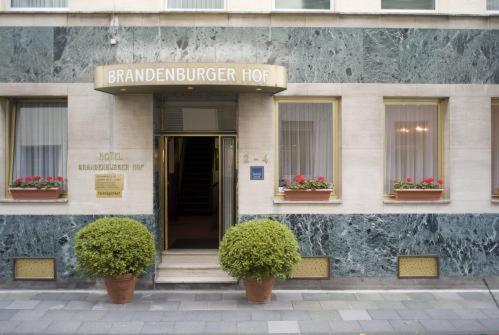 un bâtiment avec un panneau à l'avant dans l'établissement Hotel Brandenburger Hof, à Cologne