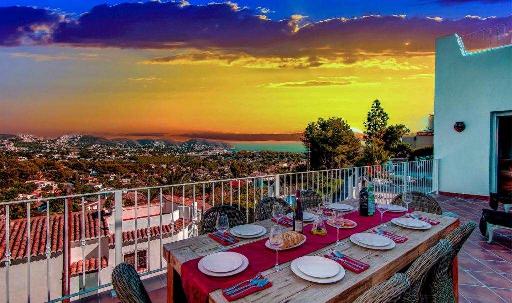 una mesa en un balcón con vistas a la ciudad en Villa Beniarres Guest House B&B in Moraira, en Moraira