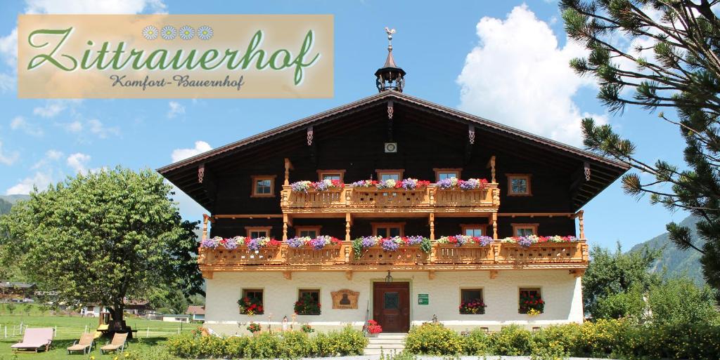 um edifício com flores em cima em ZITTRAUERHOF - Urlaub am Bauernhof Gastein em Bad Hofgastein