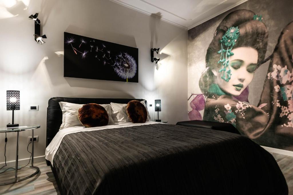 a bedroom with a black bed and a painting on the wall at Trevi & Pantheon Design Rooms in Rome