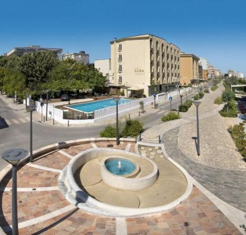 a street with a pool in the middle of a city at Hotel Alba in Misano Adriatico