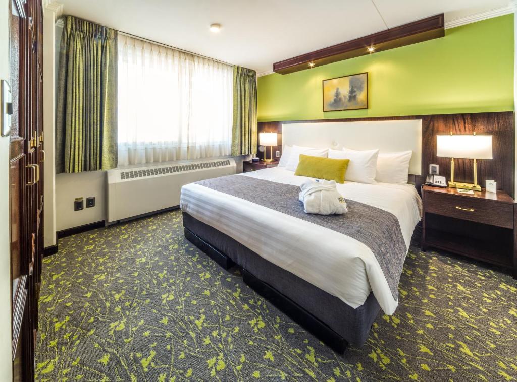 ラパスにあるリッツ アパルト ホテルの大きなベッドと大きな窓が備わるホテルルームです。