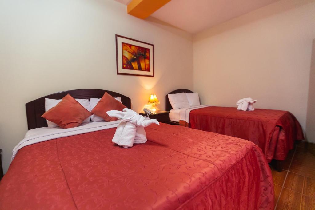 een kamer met twee bedden met knuffels erop bij Hotel Plaza Bolognesi 344 in Trujillo