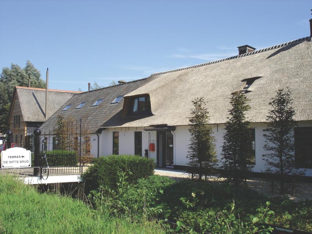 una gran casa blanca con techo de gambrel en Fletcher Hotel-Restaurant de Witte Brug en Lekkerkerk