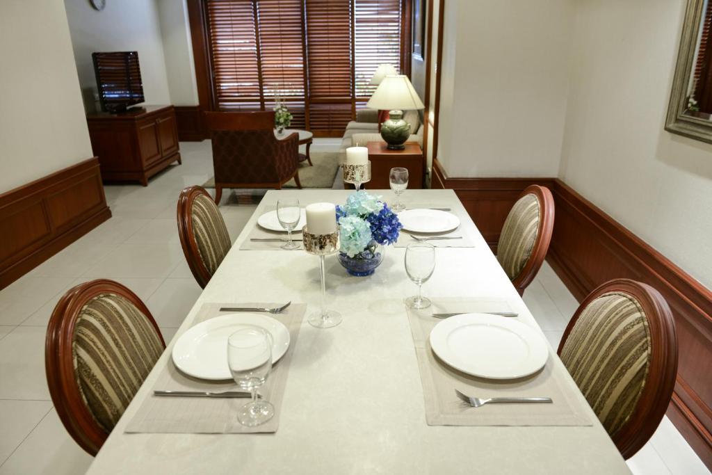 A formally set dining table in the suite beside a furnished sitting area.
