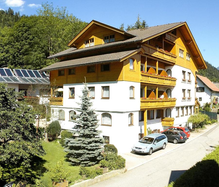 ein großes Gebäude mit davor geparkt in der Unterkunft Familienhotel Steindl in Millstatt