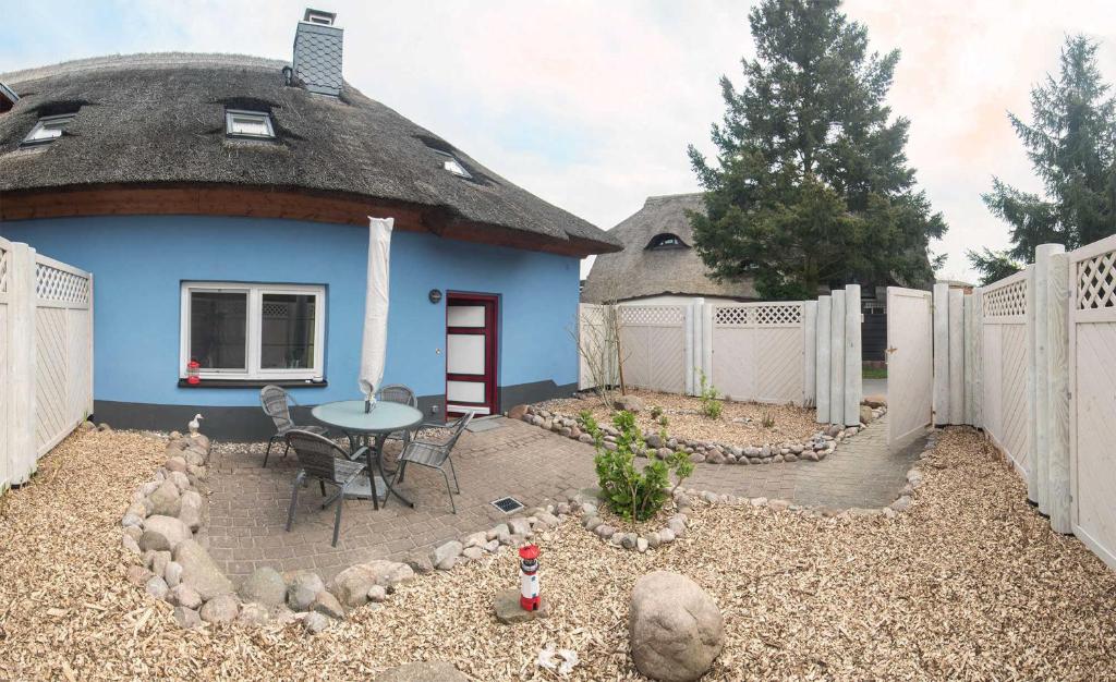 a blue house with a thatched roof and a patio at K03 Fischerkaten MARET max 4 Pers in Dorf Körkwitz