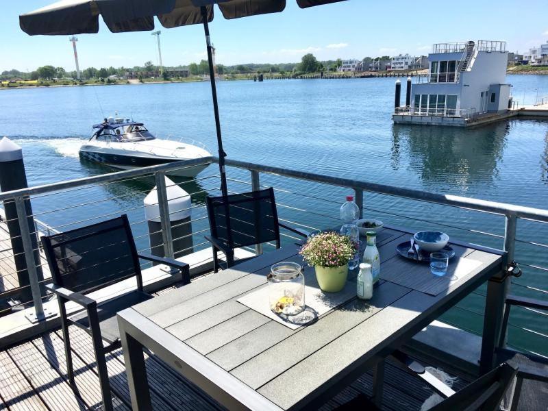 a table on the deck of a boat on the water at Schwimmendes Haus Sea Breeze in Olpenitz