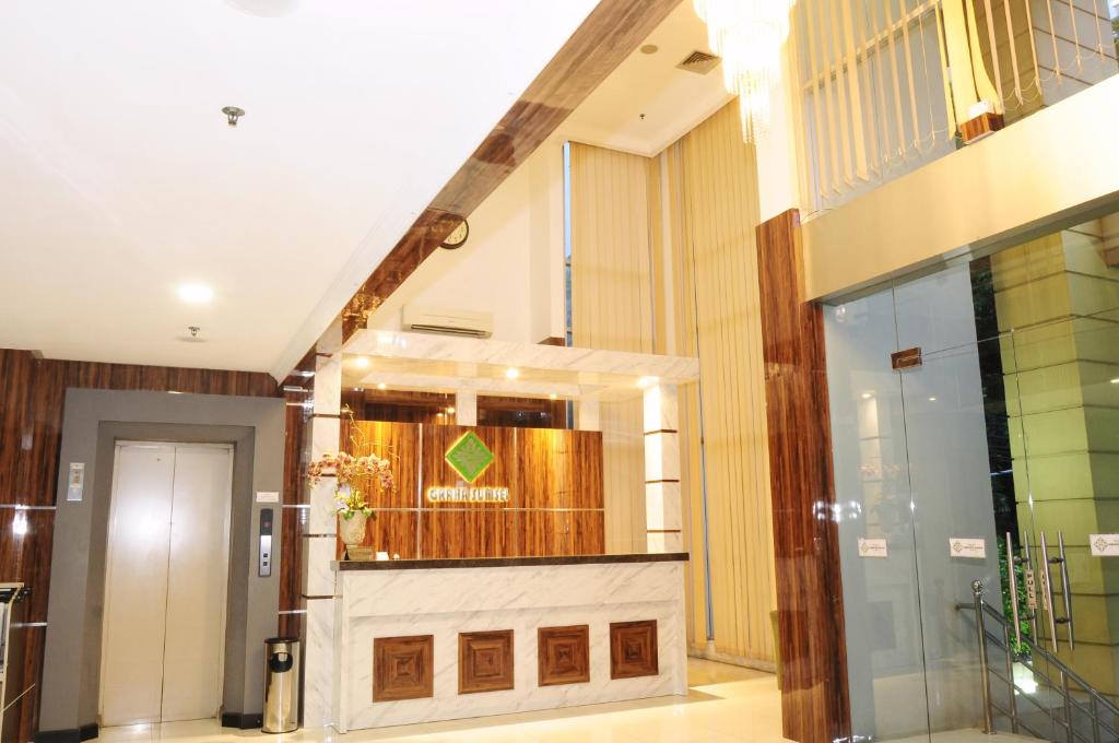 een lobby met een trap in een gebouw bij Graha SUMSEL in Jakarta