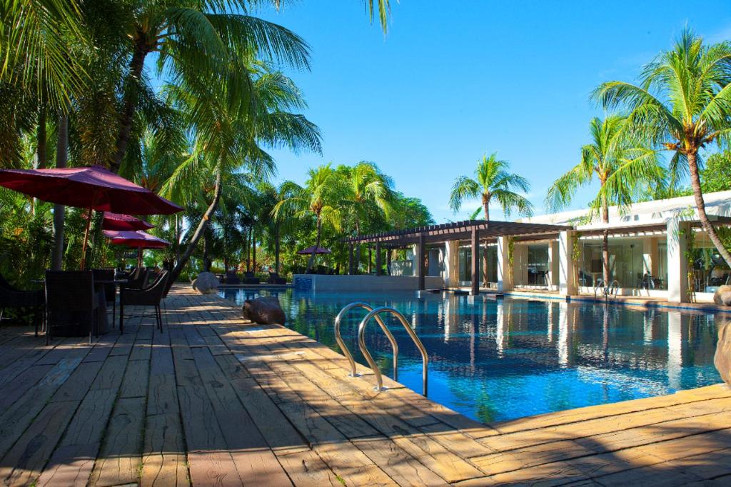uma piscina com guarda-sol e um edifício em Mount Sea Resort em Rosario